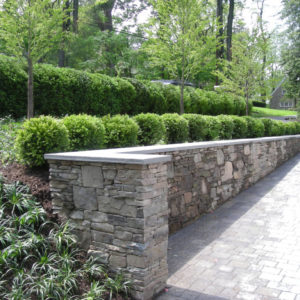 This stone retaining wall was created using natural field stone to hold back the grade allowing additional driveway space.