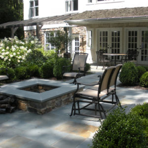 This custom stone firepit with bluestone patio provides a comfortable setting to entertain.