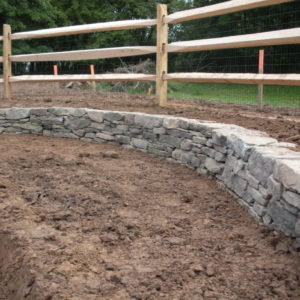 This drystacked stone retaining wall was needed to correct the grade change.