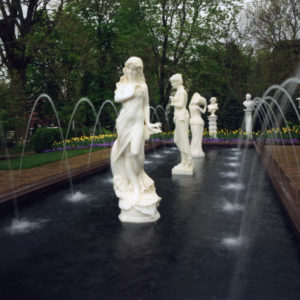 This large formal concrete pond features arching fountain streams, which adds a pleasing sound while framing the marble statues.