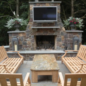 This wood burning natural stone fireplace is the main focal point of this outdoor living area.