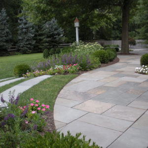 The long graceful curves of this colorful bluestone patio complements the blooming landscape.