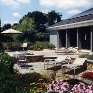 This tiered patio uses Pennsylvania bluestone and stone retaining walls to create a spacious outdoor living area.