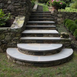 The illuminated, large rounded natural stone landing and stairs allow an easy entry to the terraced gardens day or night.