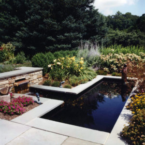 This custom water feature with spillway creates a beautiful reflecting pool for the surrounding landscape.