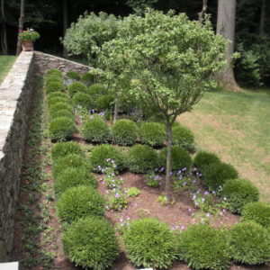 This stone retaining wall design features a hillside garden.