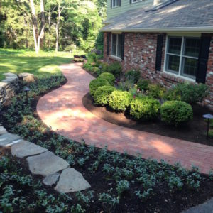 A brick walkway with gentle curves was designed through the landscape to make a colorful and inviting entrance to the home.