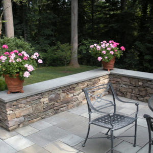 This bluestone capped seating wall was created using natural fieldstone to give the appearance of a stone stacked wall that was built long ago.