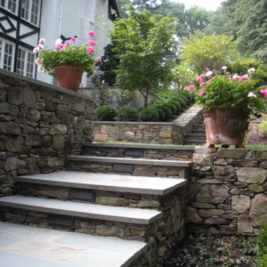 These masonry fieldstone steps capped with bluestone give a dry laid appearance matching the walls.
