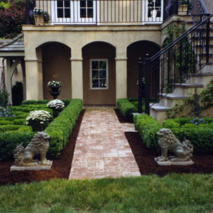 This scroll garden’s walkway was created using distressed brick to blend with the home’s architecture.