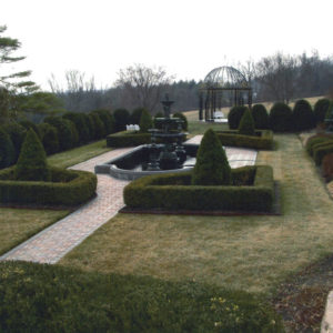 The design of this unique shaped concrete pond with large fountain blends into the formal gardens that surround it.