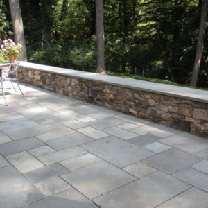 This natural stone sitting wall allows for extra seating on the patio.
