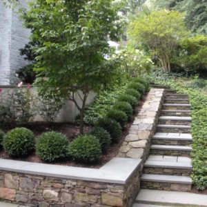 The combination of natural stone walls and bluestone capped stairs offers an outside access to the backyard.